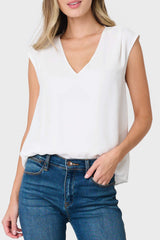 Woman modeling The Favorite V-Neck Blouse in Ivory styled with denim pants