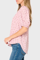Side of Woman modeling Avery Elbow Sleeve Top in pink floral print featuring shirttail hem