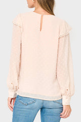 Light pink blouse with sheer sleeves worn by a person on a light gray background