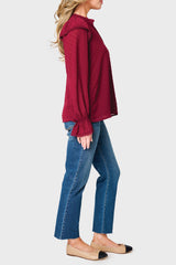Side view of Woman modeling Holly Ruffled Cuff Blouse in Wine styled with denim