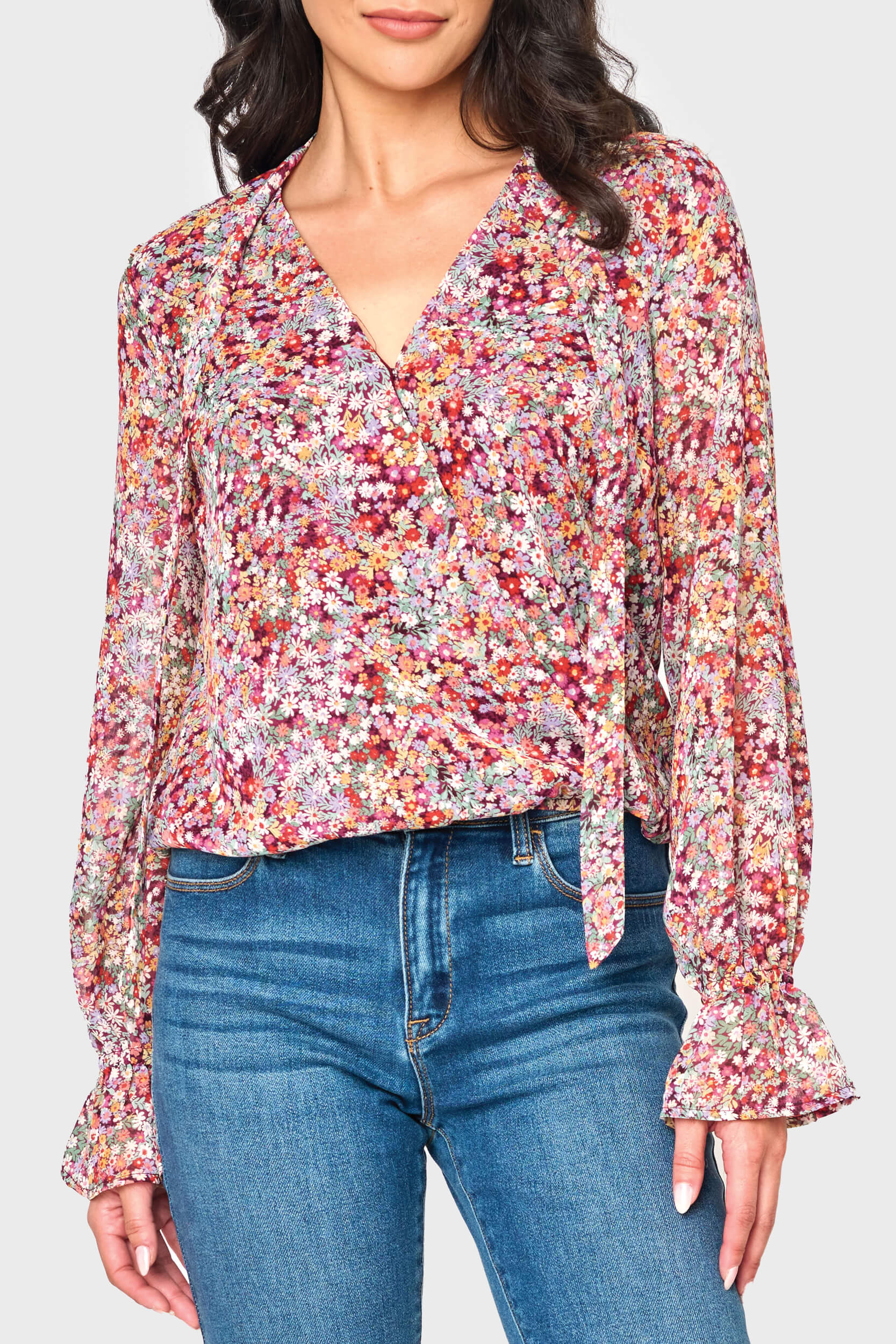 Woman modeling Long Sleeve Surplice Blouse With Ruffle Sleeve in Berry Ditsy floral print styled for work