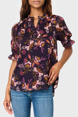 Model wearing Dianthus Henley Puff Sleeve Chiffon Blouse in Purple floral print styled business casual