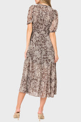 Woman wearing a floral patterned dress on a plain background