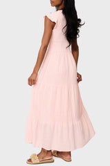 Side of Woman modeling Flutter Sleeve Smocked V Neck Tiered Maxi Dress in Pearl blush pink, styled for work