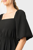 Close up of women wearing square neck black dress with puff sleeve