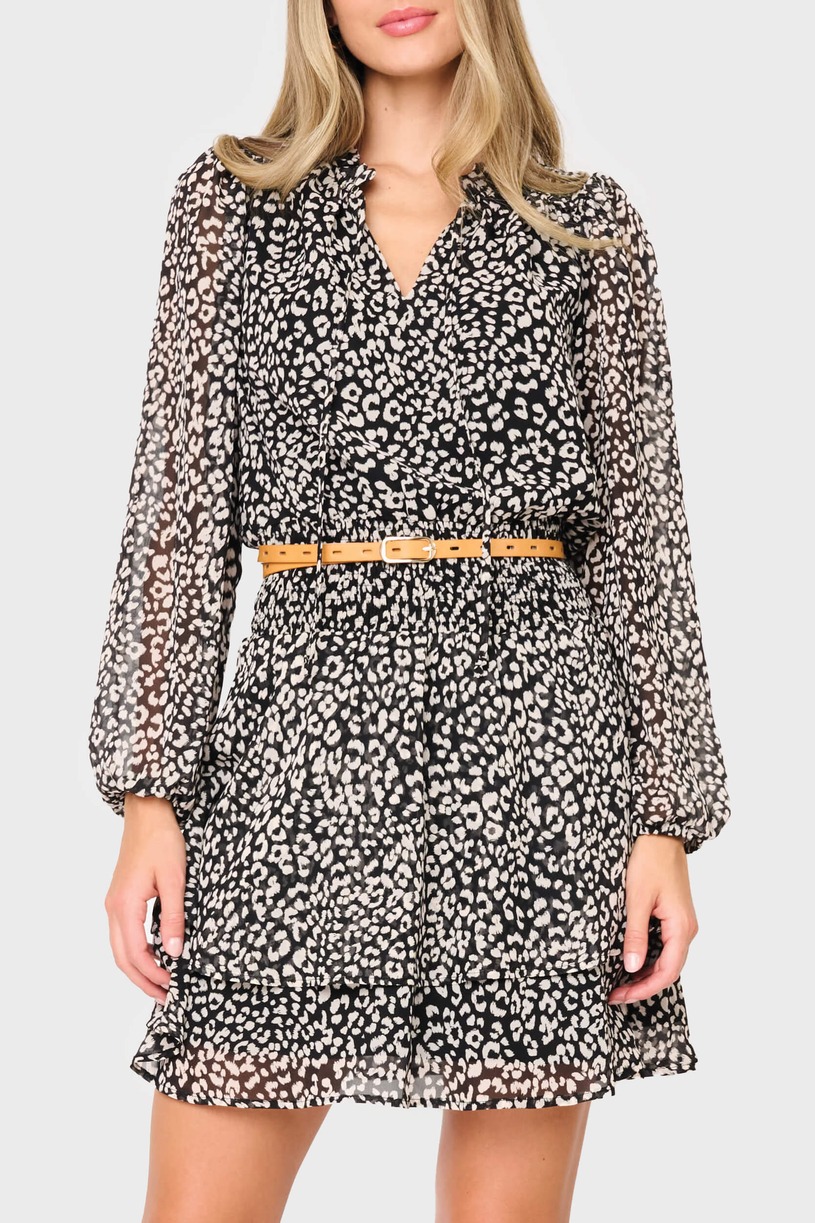 Woman modeling Long Sleeve Isla Smocked Day Dress in Black Cheetah Print  styled for weekend date night