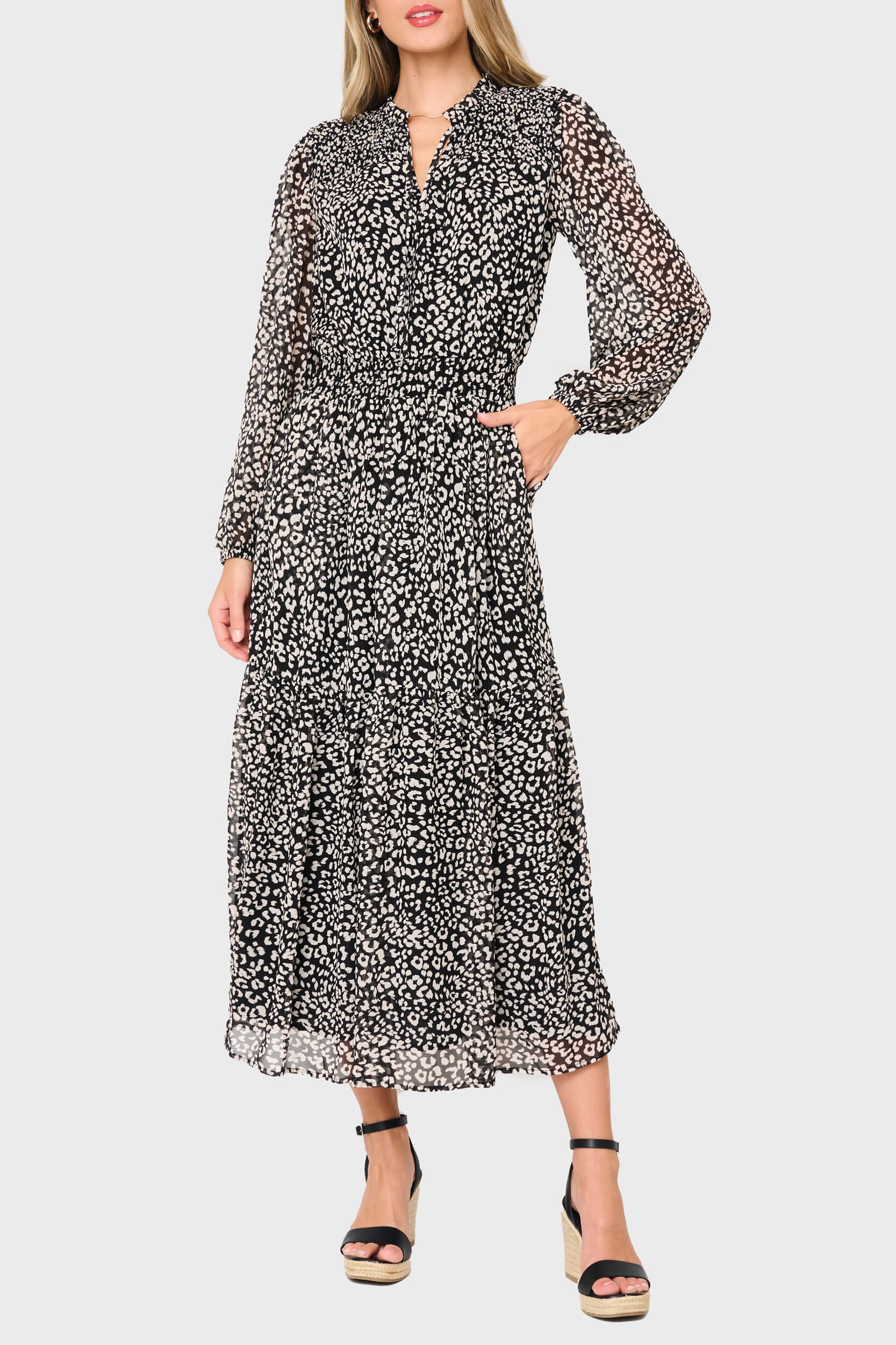 Woman wearing a black and white patterned dress on a plain background