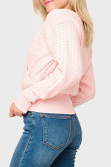 Side of woman modeling Pointelle Surplice Sweater in light pink smoke, styled for work