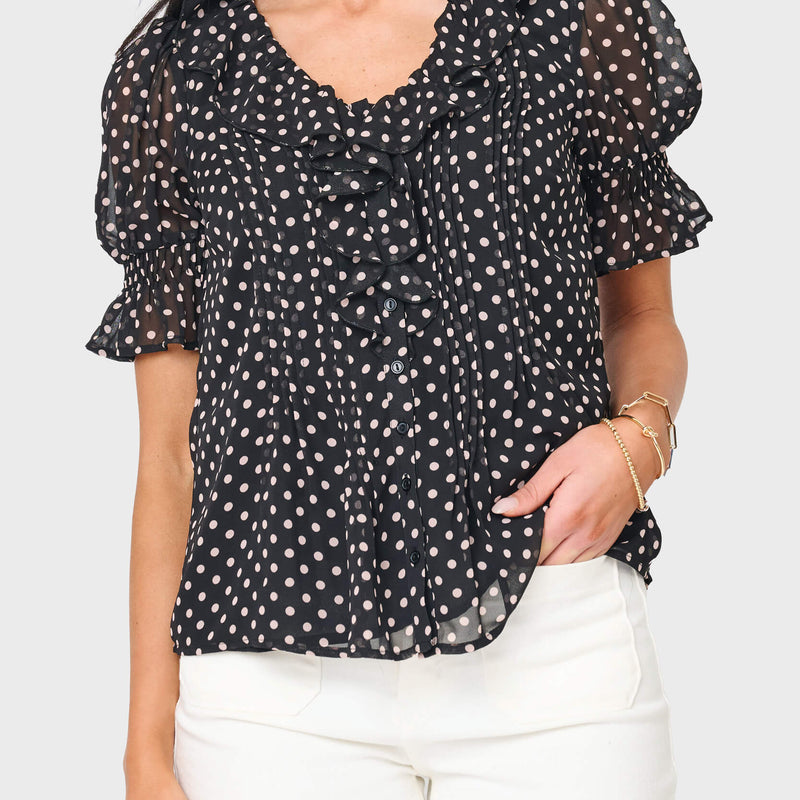woman modeling Khloe Ruffle Button Down Blouse in black polka dot styled for everyday, work, and nights out