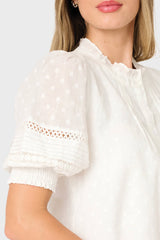 White blouse with lace details on a plain background