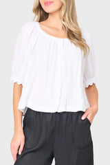 Woman modeling Lily Scallop Puff Sleeve Linen Top in White styled for vacation and weekends