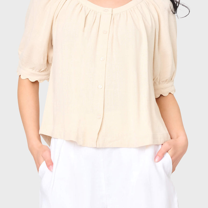 Woman modeling Lily Scallop Puff Sleeve Linen Top in Natural beige styled for vacations and weekends