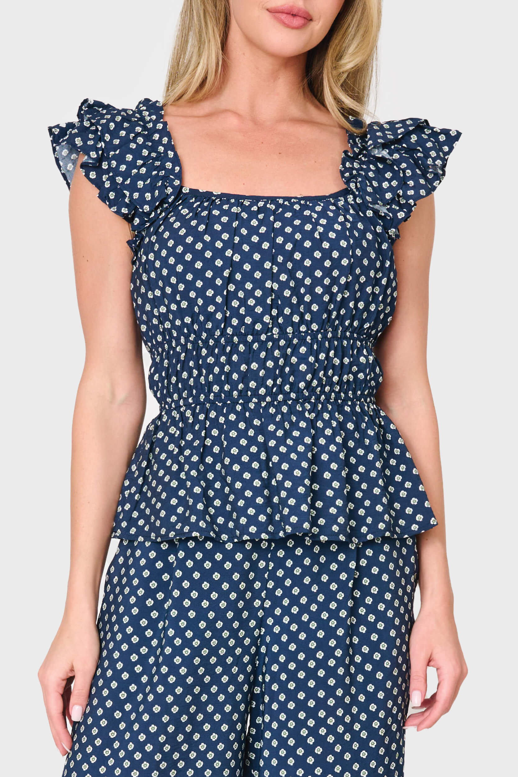 Woman modeling Elle Boho Flutter Sleeve Top in Navy daisy dot print styled as a set