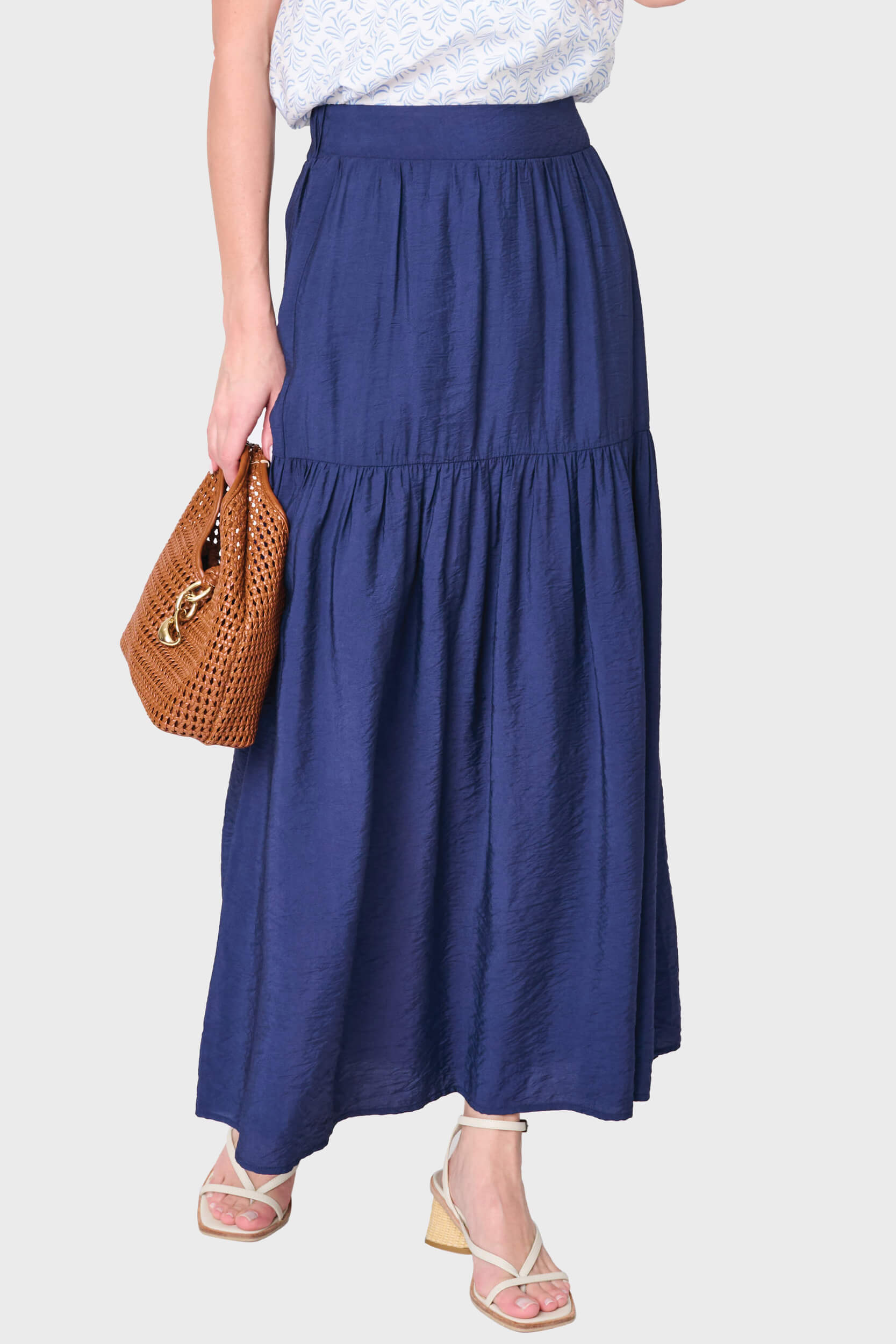 Woman modeling Playa Tiered Maxi Skirt in navy blue styled for work and everyday