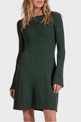 Woman wearing a green ribbed dress against a white background