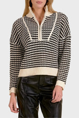 Woman wearing a black and white patterned sweater with a beige collar against a beige background