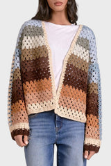 Woman wearing a multicolored crochet cardigan on a white background