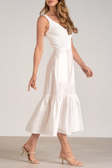 Woman wearing a white dress against a plain background