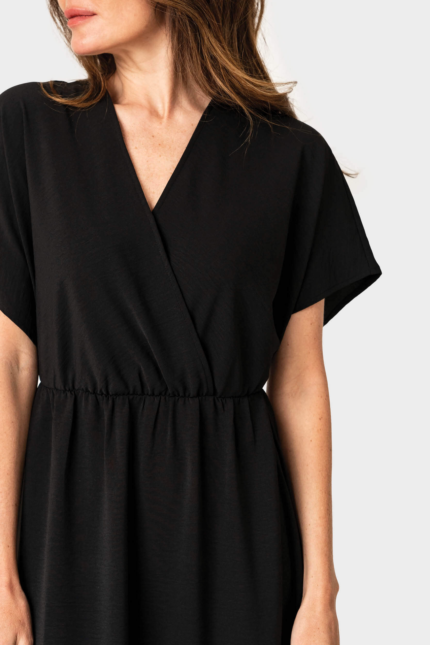 Close-up of Woman wearing Tie Back Surplice Dress in Black