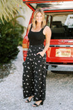 Erin of Living in Yellow Wearing Smocked Waist Wide Leg Pant in Black Floral