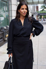 Front of Woman wearing Long Sleeve Blouse with Ruffled Cuff in Black